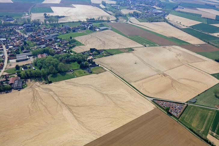 Champs et villages vus du ciel, on discerne d'anciennes coulées de boue dans les champs
